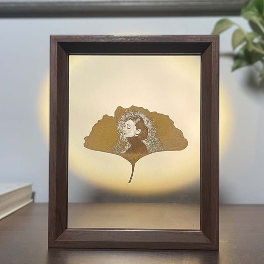 Framed artwork with Audrey Hepburn on a ginkgo leaf design on a neutral background