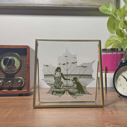 Framed artwork of a woman and dog on maple leaves with a vintage radio and clock in the background.
