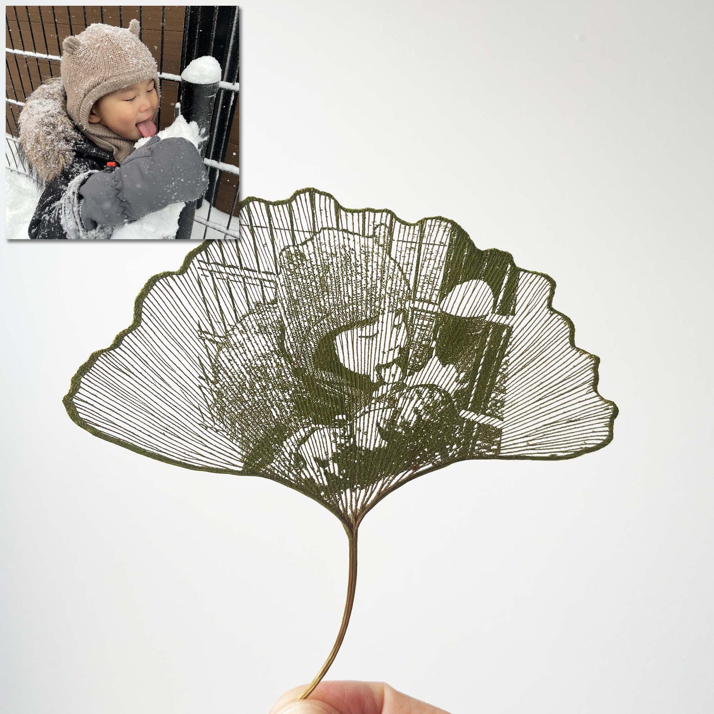 Artistic leaf cutout with a child playing in the snow in the corner